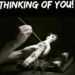 Hand holding a voodoo doll with needles, captioned 'Thinking of You.'