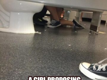 A humorous scene of a girl kneeling in a bathroom stall, resembling a proposal.