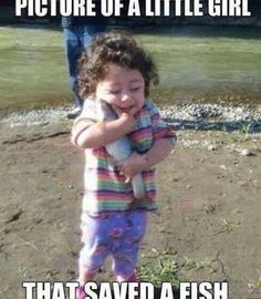 A little girl happily holding a fish, thinking she saved it from drowning.
