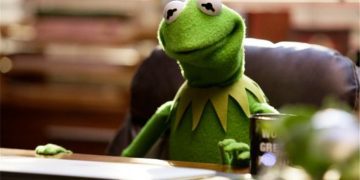 Kermit the Frog sitting at a desk, looking thoughtful about leaving work early.