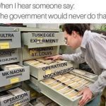 Person examining file cabinet labeled with government conspiracy projects.