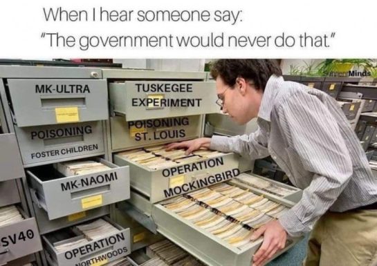 Person examining file cabinet labeled with government conspiracy projects.