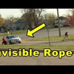 People pretend to hold an invisible rope across the road.