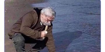 Man pretending to hammer nails into the beach