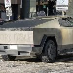Cybertruck labeled as Dork Mobile on snowy street.
