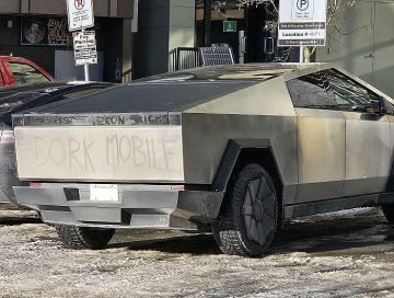 Cybertruck labeled as Dork Mobile on snowy street.
