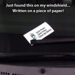 Ironic paper note on windshield saying, "Save paper."