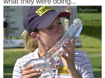 Woman kisses bizarrely shaped golf trophy with a smirk.