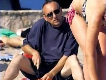 Man distracted by bikini girl while cutting fruit, risky beach prank