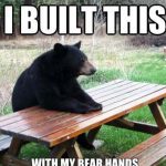 Black bear sitting at picnic table with text "I built this with my bear hands"