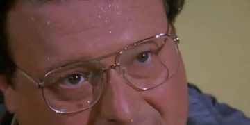 Person sweating as friends teach card game rules, looking confused