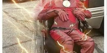 Man in superhero costume with humorous overlay about camera flash.