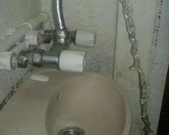 Hilarious DIY plumbing fail with a faucet missing the sink entirely.