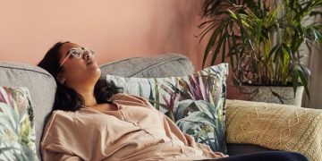 Woman on couch experiencing an existential crisis, dark humor.