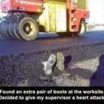 Roller flattens road with boots sticking out in a construction prank.
