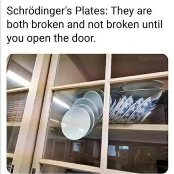 A stack of plates precariously balanced behind a glass cabinet door.