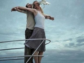 Couple on a boat deck doing Titanic pose gets interrupted by seagull.