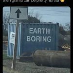 Blue container with "Earth Boring" graffiti under a road sign.
