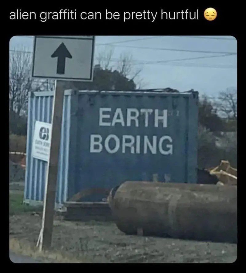 Blue container with "Earth Boring" graffiti under a road sign.