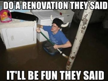 Person in flooded basement during renovation fail, paddling with a broom.