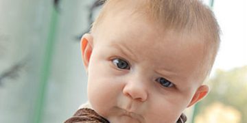 Baby looking confused, questioning why spoons don't sound like airplanes.