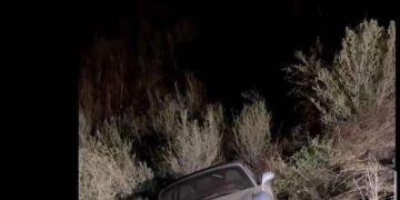 Car crashed in bushes with humorous text exchange about driving.