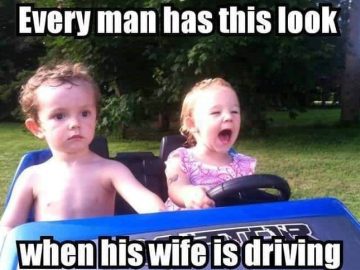 Toddler driving toy car with serious passenger expression