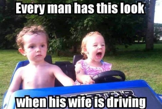 Toddler driving toy car with serious passenger expression