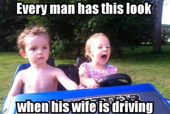 Toddler driving toy car with serious passenger expression