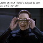 Person tries friend's glasses; humorous vision test moment.