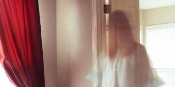 Ghostly figure opening a door in a haunted house meme