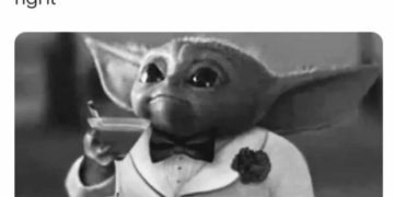 Baby Alien in tuxedo holding drink, waiting for Google results.