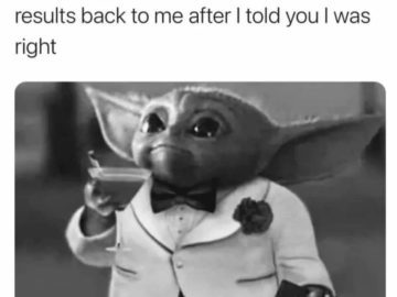 Baby Alien in tuxedo holding drink, waiting for Google results.