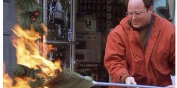 Man in red jacket trying to extinguish a Christmas tree fire