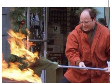 Man in red jacket trying to extinguish a Christmas tree fire