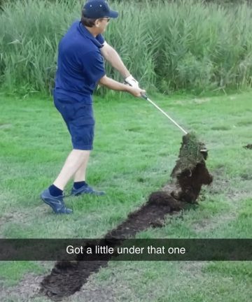 Golfer swings and lifts a giant piece of turf into the air.