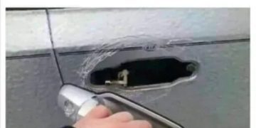 Hand holding a broken car door handle with text about life