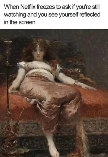 Woman sees own reflection on TV screen during Netflix pause.