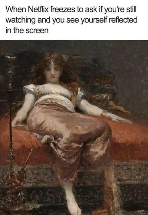 Woman sees own reflection on TV screen during Netflix pause.