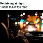 Driver navigating a rainy, blurry road at night with colorful lights.