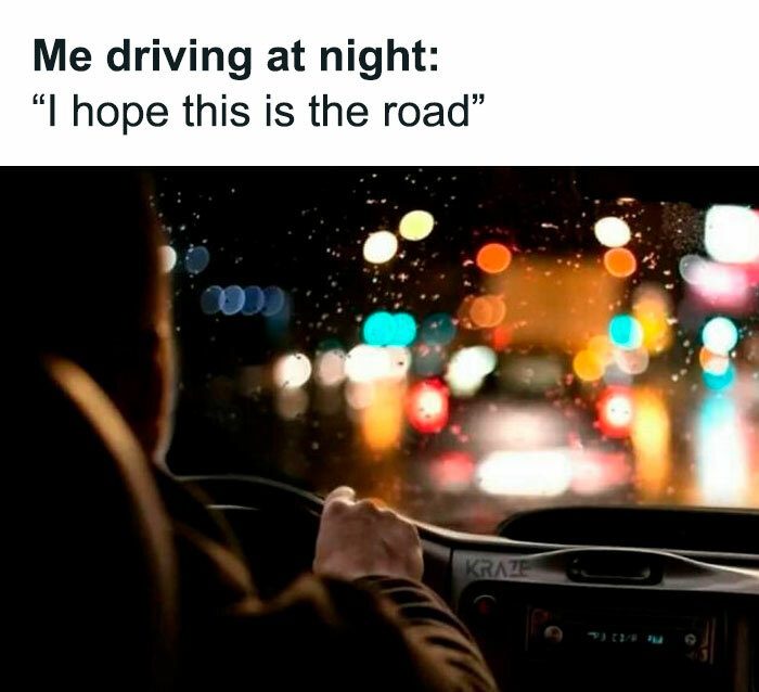Driver navigating a rainy, blurry road at night with colorful lights.