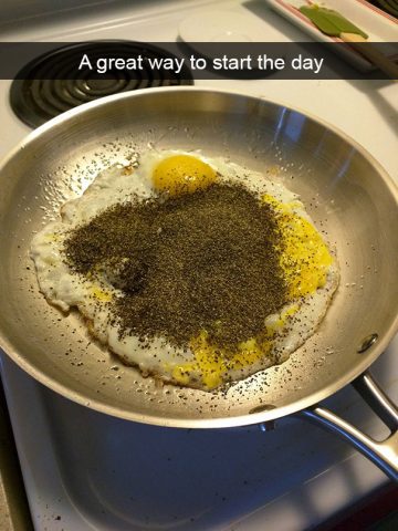 Fried egg covered in way too much pepper in a pan