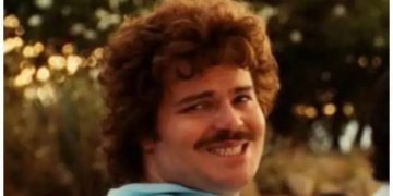 Man waiting awkwardly for help at self-checkout