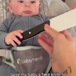 Baby holding a fake knife for a prank on dad