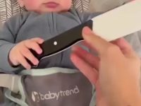 Baby holding a fake knife for a prank on dad