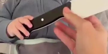 Baby holding a fake knife for a prank on dad