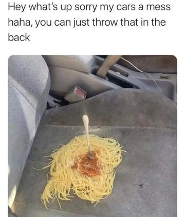 Spaghetti spilled on car seat with a fork sticking out
