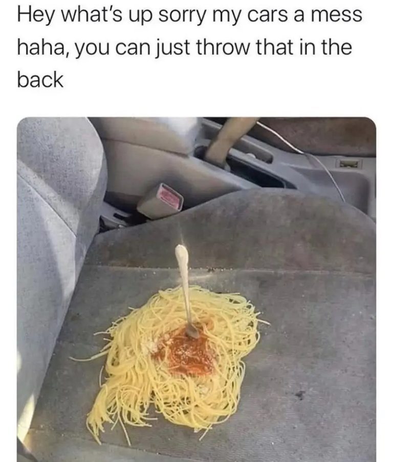 Spaghetti spilled on car seat with a fork sticking out