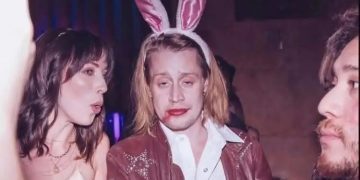 Person with bunny ears, makeup smeared, at a party looks tired.