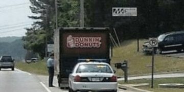 Police car behind Dunkin Donuts truck with a traffic stop joke.